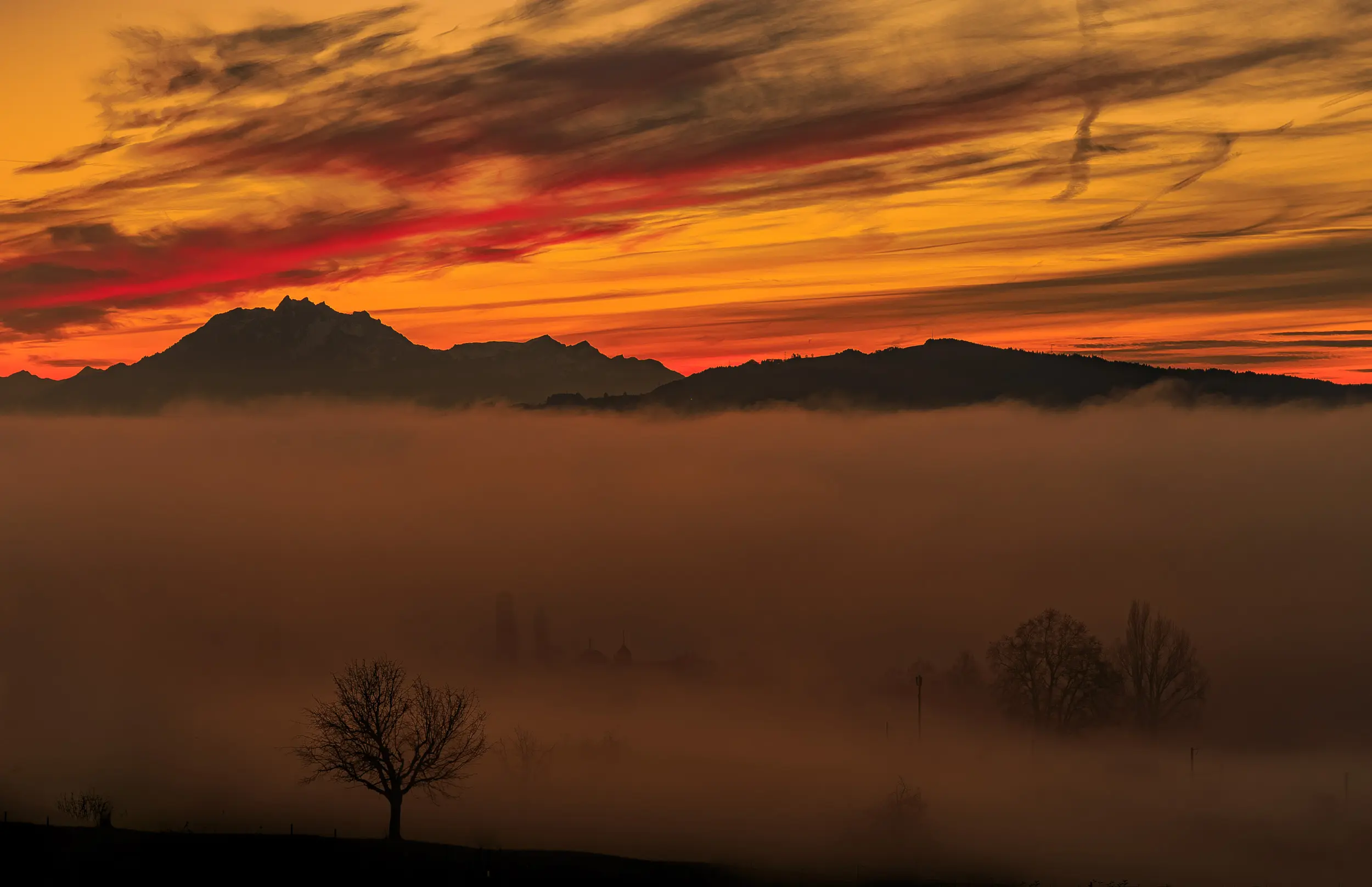 Mount Pilatus above a sea of fog at sunset